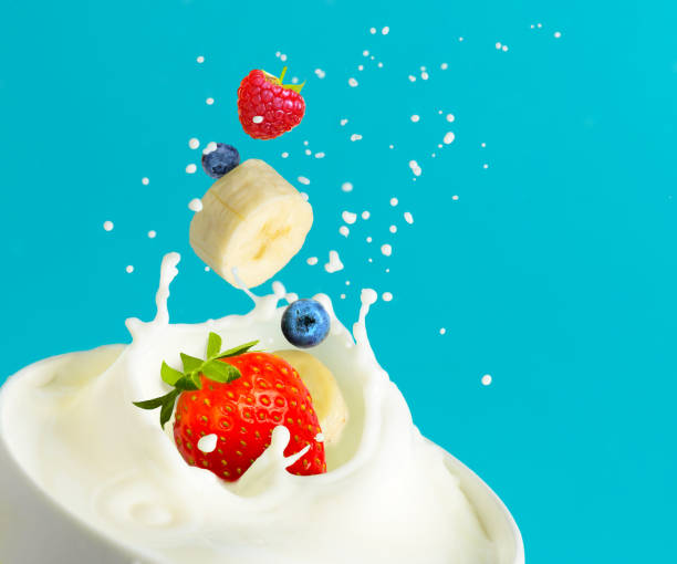 istock Fruit berry mix falling into bowl with milk and splashing on aqua blue background. Copy space 1212186568