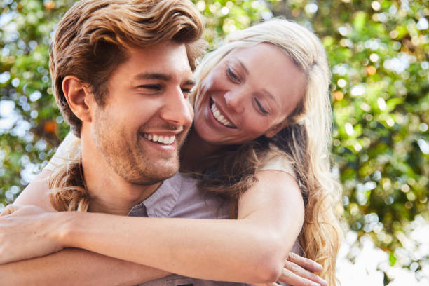 istock Smiling man carrying his girlfriend outside on a sunny day 1212186721