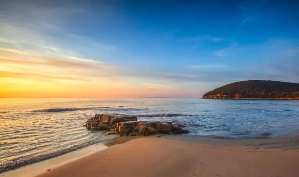 Photo of Sunset in Cala Violina bay beach in Maremma, Tuscany. Mediterranean sea. Italy.