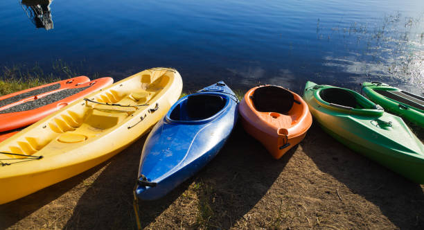 coloridos kayaks junto al lago - canoa con balancín fotografías e imágenes de stock