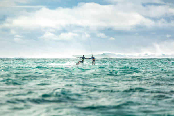 istock Two men shaking hands while kite surfing on Mauritius island. 1212196128
