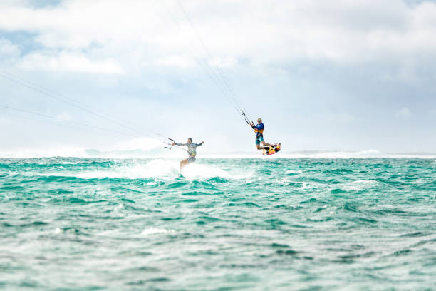 due uomini a bordo di kiteboarding insieme sull'isola di mauritius - wakeboarding surfing men vacations foto e immagini stock