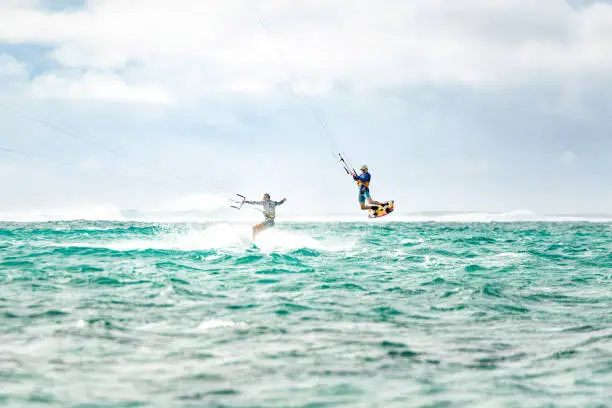 Photo of Two men kiteboarding together at Mauritius island