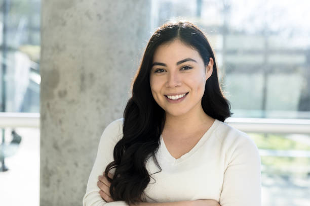 istock Young woman with arms crossed smiles for camera 1212201422
