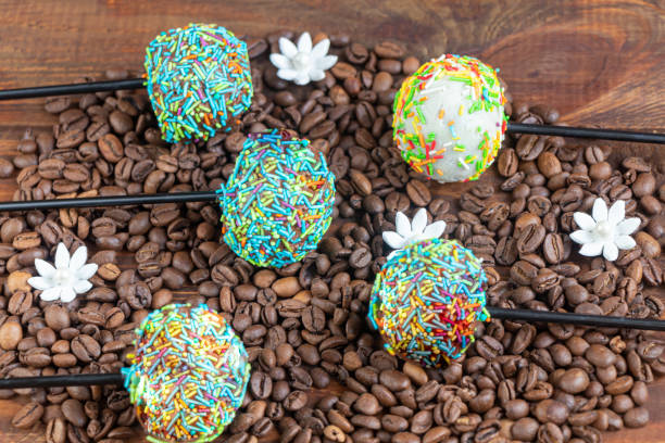 istock A colorful cake pops up, lying on a table. It is covered with sweet multi-colored sweets. 1212205420