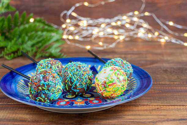 istock A colorful cake pops up, lying on a table. It is covered with sweet multi-colored sweets. 1212205430