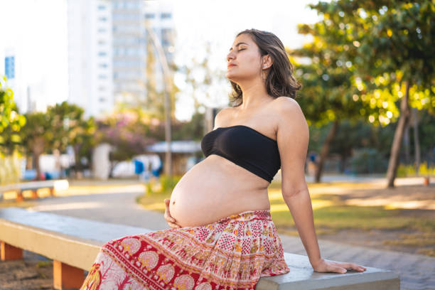 istock Pregnant woman sitting on the square bench 1212208056