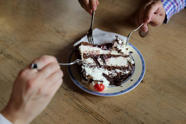 persone che condividono la torta della foresta nera in un bar - dessert fruit torte red foto e immagini stock