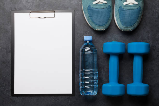 istock Fitness equipment and sheet for workout plan 1212210831