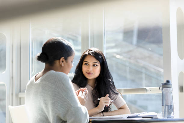 istock Attentive Hispanic college student studying with female friend 1212211552