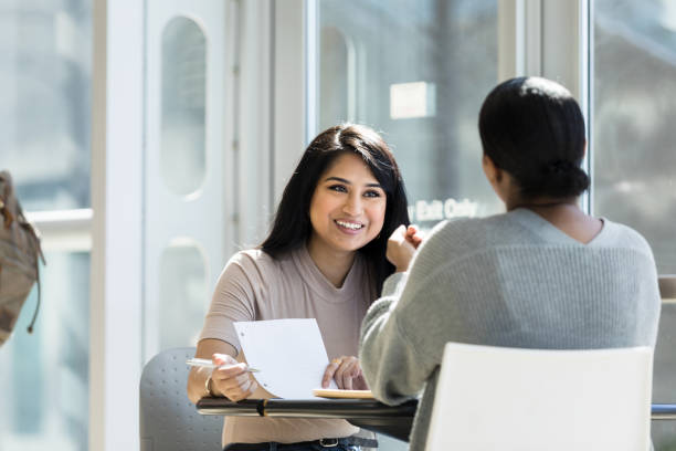 istock Beautiful college student studies with friend 1212211556