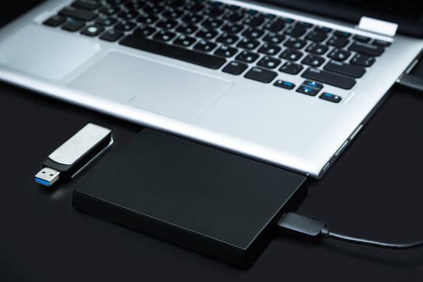 istock External hard drive connected to the laptop and USB flash drive 1212212127