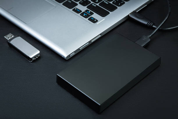 istock External hdd connected to the laptop and USB flash drive 1212212149