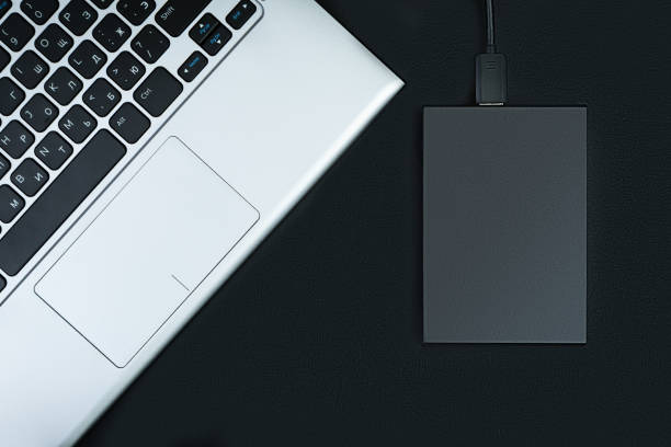 istock Part of the laptop with an external hard drive 1212212152
