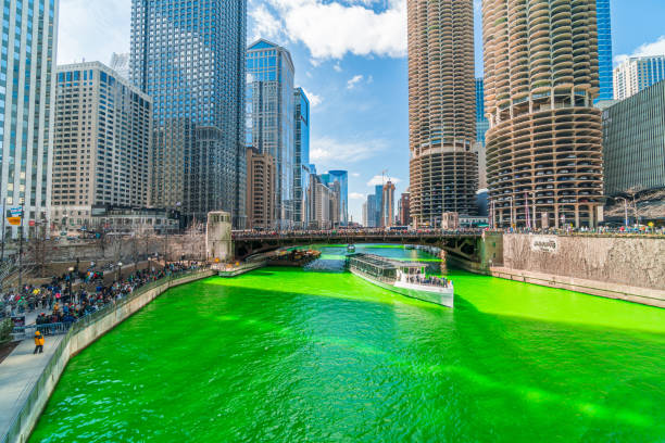 Chicago, USA - Mar 2019 : Unrecognizable people and tourist on the Yacht running over the Chicago river walk in Saint Patrick's day with green color river on March 16, 2019, in Chicago, illinois, USA
