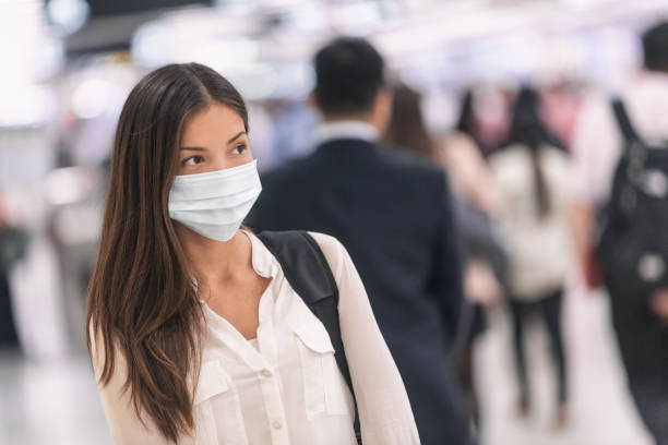Virus mask Asian woman travel wearing face protection in prevention for coronavirus in China. Lady walking in public space bus station or airport Virus mask Asian woman travel wearing face protection in prevention for coronavirus in China. Lady walking in public space bus station or airport. commuter train photos stock pictures, royalty-free photos & images