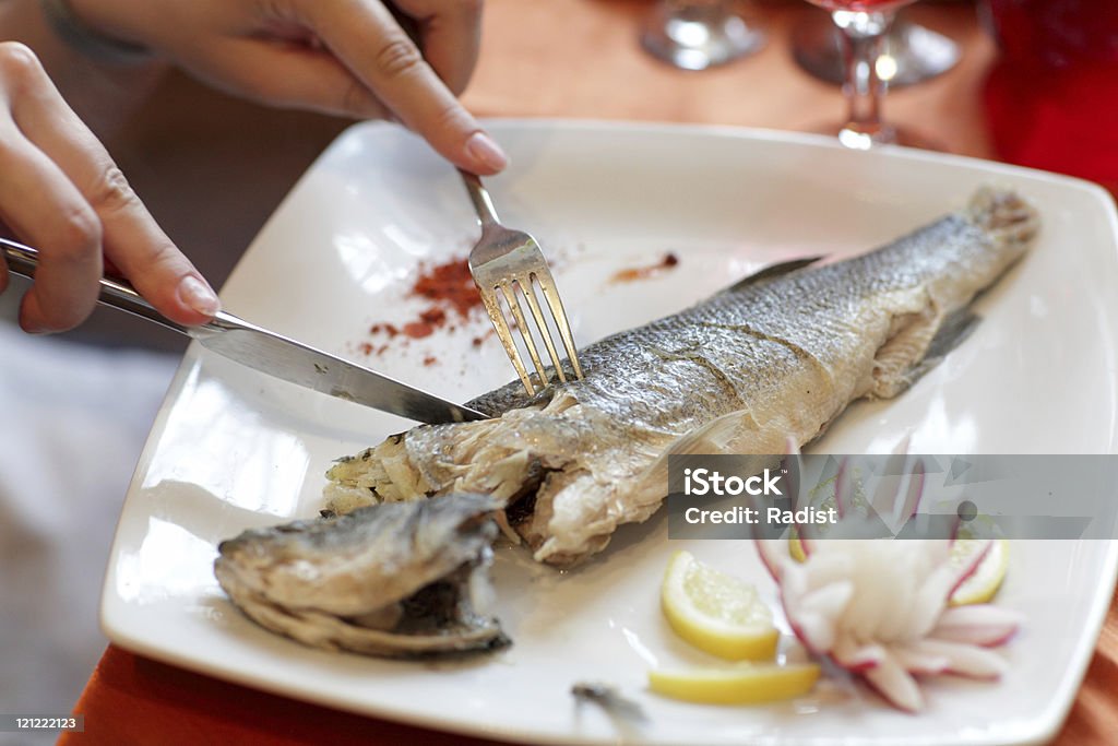 Woman cuts dorado fish  Baking Stock Photo