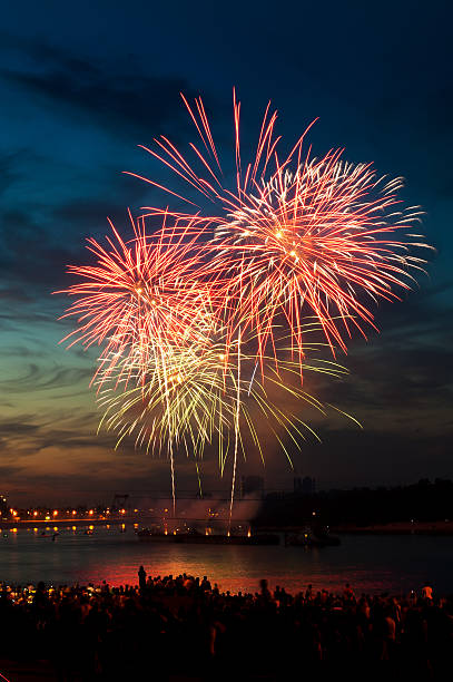 istock Red and white fireworks display over the water at nighttime 121222307