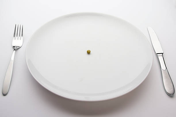 Single pea on a dinner plate stock photo