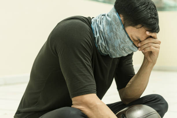 istock Sad stress chinese man wearing a mask suffering from a crisis. 1212224439