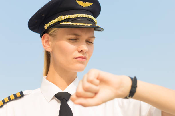 istock Professional captain pilot checking the time on her watch at the airport. Delay flight. Punctuality. 1212224488