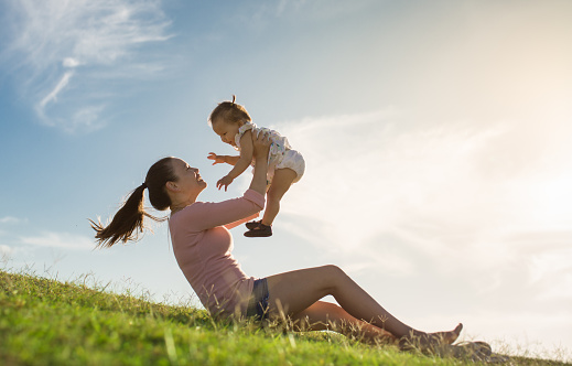 A family playing at the park outdoor, having fun together laughing and smiling.