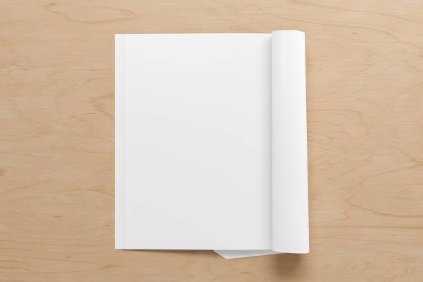 istock Blank magazine page. Workspace with folded magazine mock up on the desk. 1212226618