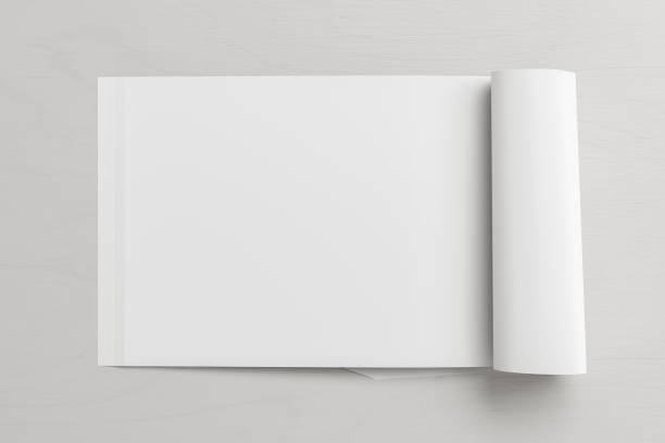 istock Blank magazine page. Workspace with folded magazine mock up on the desk. 1212226645