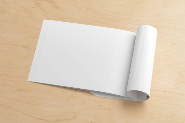 istock Blank magazine page. Workspace with folded magazine mock up on the desk. 1212226694