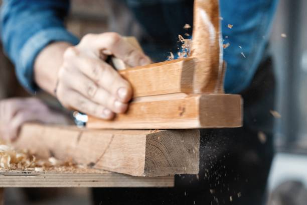 istock carpenter working with plane on wooden background. 1212230495