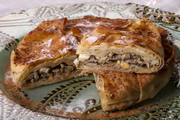 Moroccan pastilla (pastela) slices on vintage patterned plate. Chicken Bastilla is Morocco's famous chicken pie. Horizontal close-up.