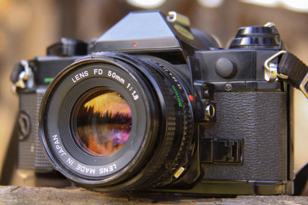 istock Sunset in the forest reflected in analog film camera lens 1212233180