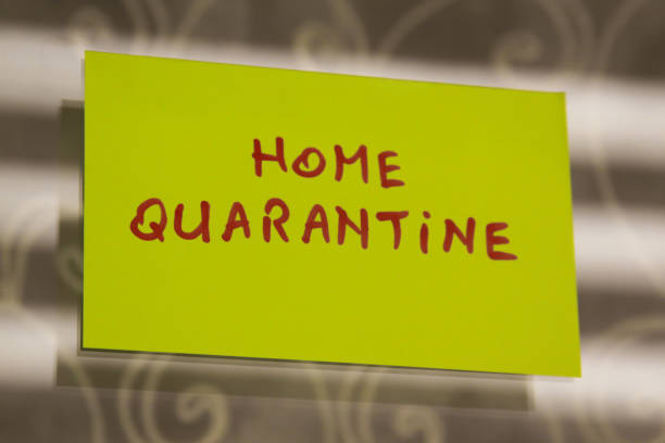 Sticky note on window with Home Quarantine writing text message stock photo