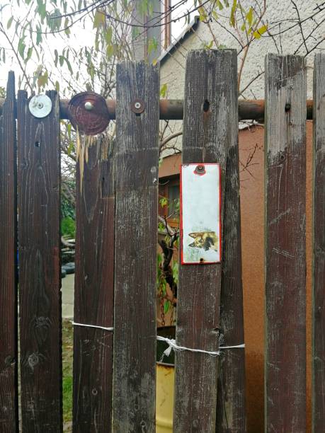 istock Wooden board gate, old and poorly maintained, in disastrous condition 1212235859