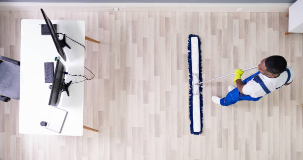 istock Male Janitor Cleaning Floor In Office 1212236110