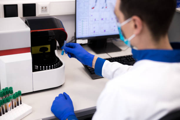 istock Scientist holding test tube while working on medical research 1212239461