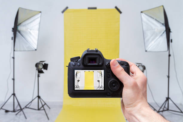 tomar fotos en un estudio fotográfico con telón de fondo amarillo - office tool flash fotografías e imágenes de stock