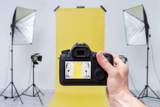 scattare foto in uno studio fotografico con sfondo giallo - office tool flash foto e immagini stock