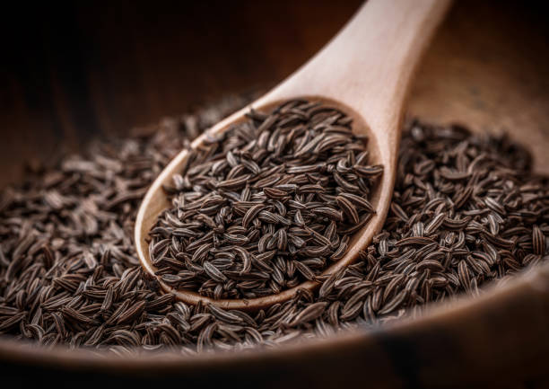 istock Cumin seeds in wooden bowl and spoon selective focus arrangement 1212239932