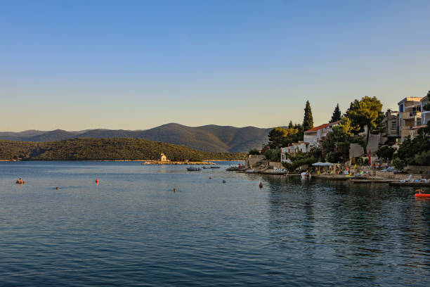 Klek, Croatia - July 6, 2019: Small village Klek and a lagoon with tiny island with church in Adriatic sea in Croatia