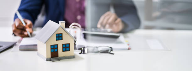 istock Businessman Calculating Invoice With Model Home 1212241501