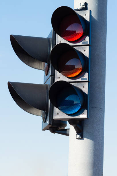 istock Traffic light on a bright sunny day, all three colors shining bright 1212242952