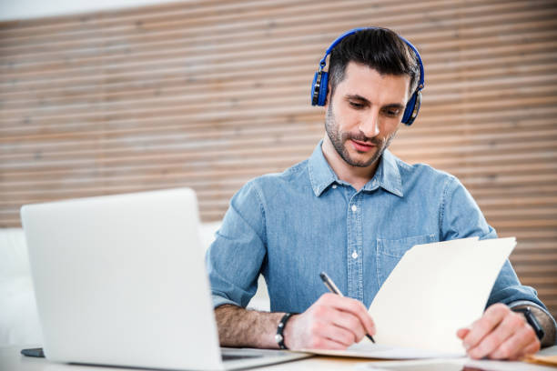 istock Smiling man making notes during online connection stock photo 1212245306