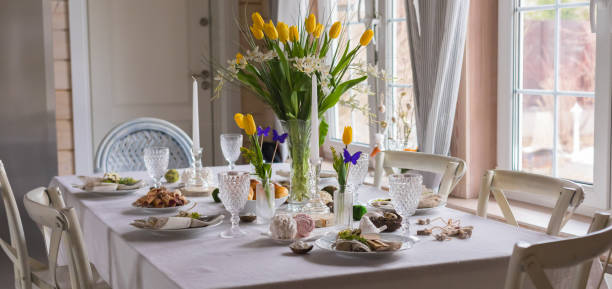 istock Easter festive spring table setting decoration, eggs in nest, fresh yellow tulips, marshmallows, selective focus banner 1212245627