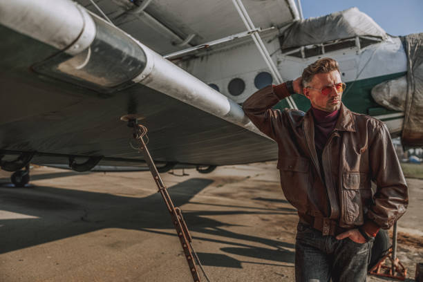 istock Smiling young man posing near plane outdoors 1212249959