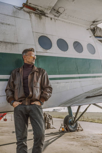istock Young stylish man looking away near airplane 1212250001