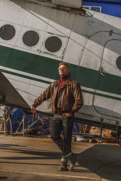 istock Smiling young man is standing near airplane 1212250025
