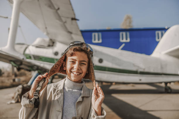 istock Happy little kid is standing near airplane 1212250046