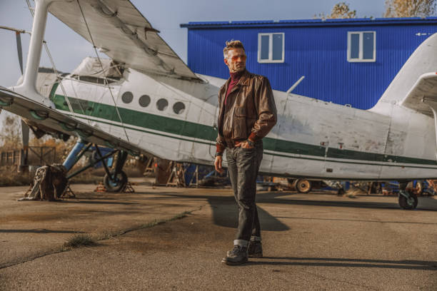 istock Stylish young man is staying near airplane 1212250062