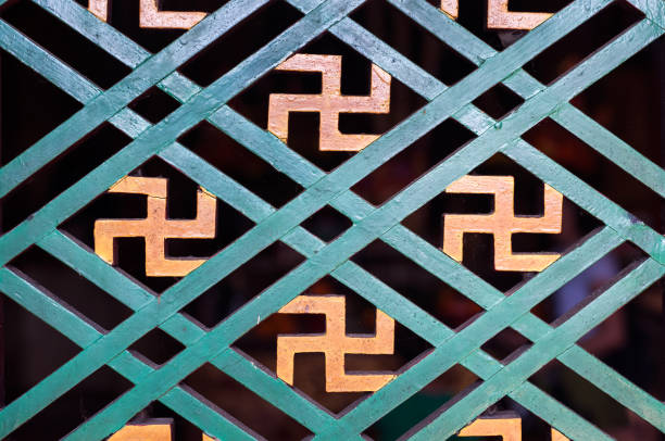 buddyjski symbol manji widziany w detalu drewnianej ramy okiennej w świątyni w hongkongu - swastyka hinduska zdjęcia i obrazy z banku zdjęć